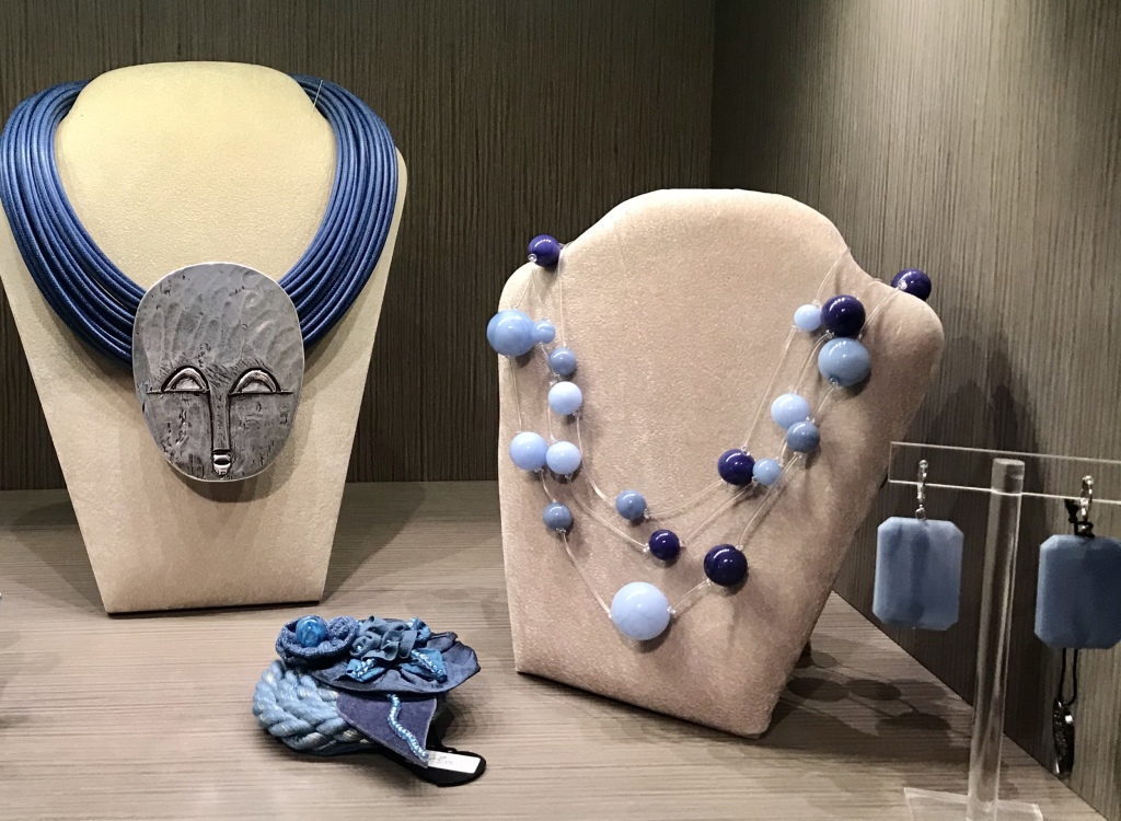 Una delle nostre vetrine azzurro jeans: Scenografica collana con mascherone argento, "Collana palline sospese" girata tre volte ad effetto girocollo, orecchini in plexiglas rettangolari e splendida spilla ricamata a mano.